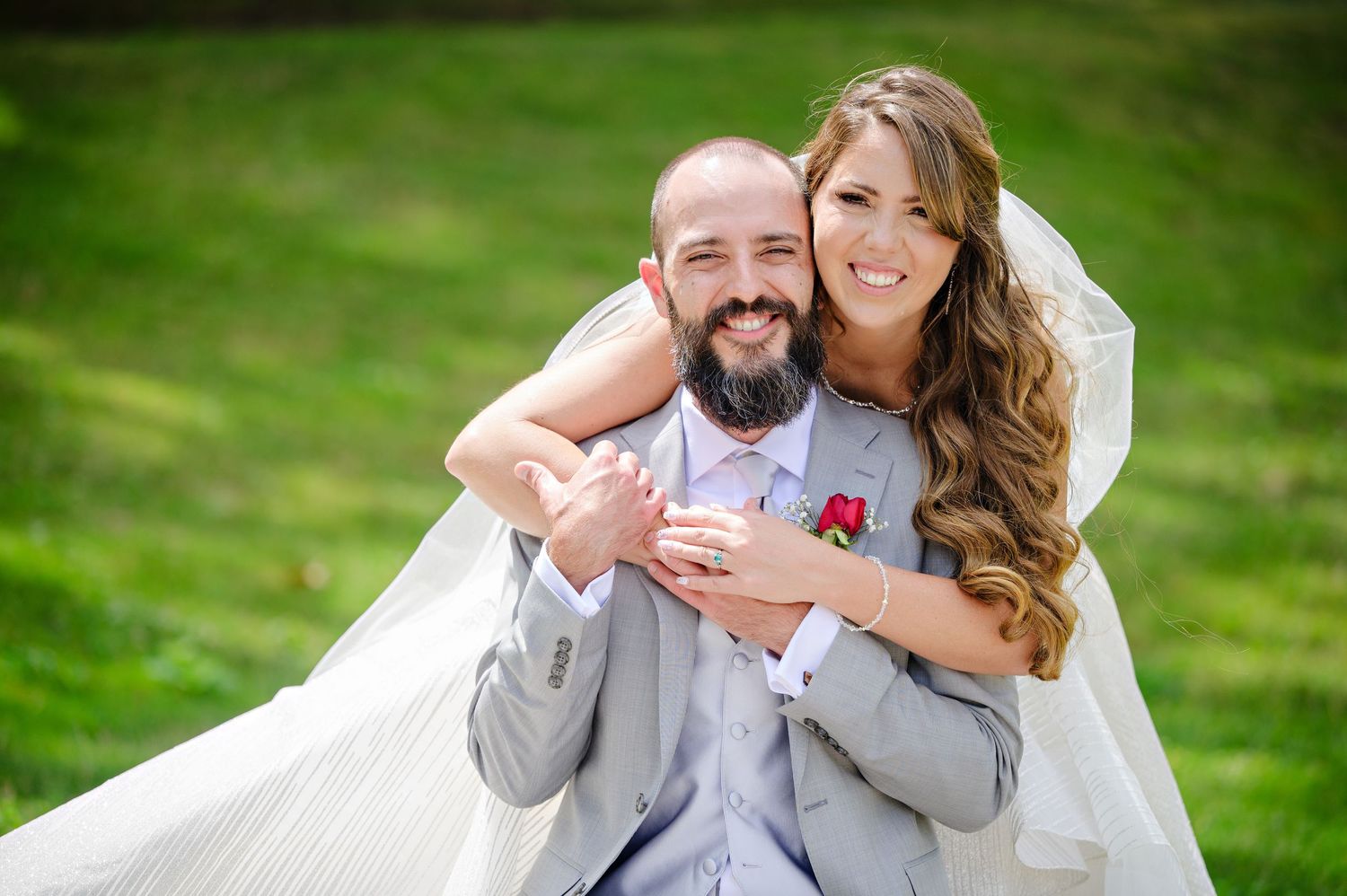 Bride hugging Groom during their wedding portraits at Wade Oval Lagoon before their wedding at Music Box Supper Club in Cleveland Ohio