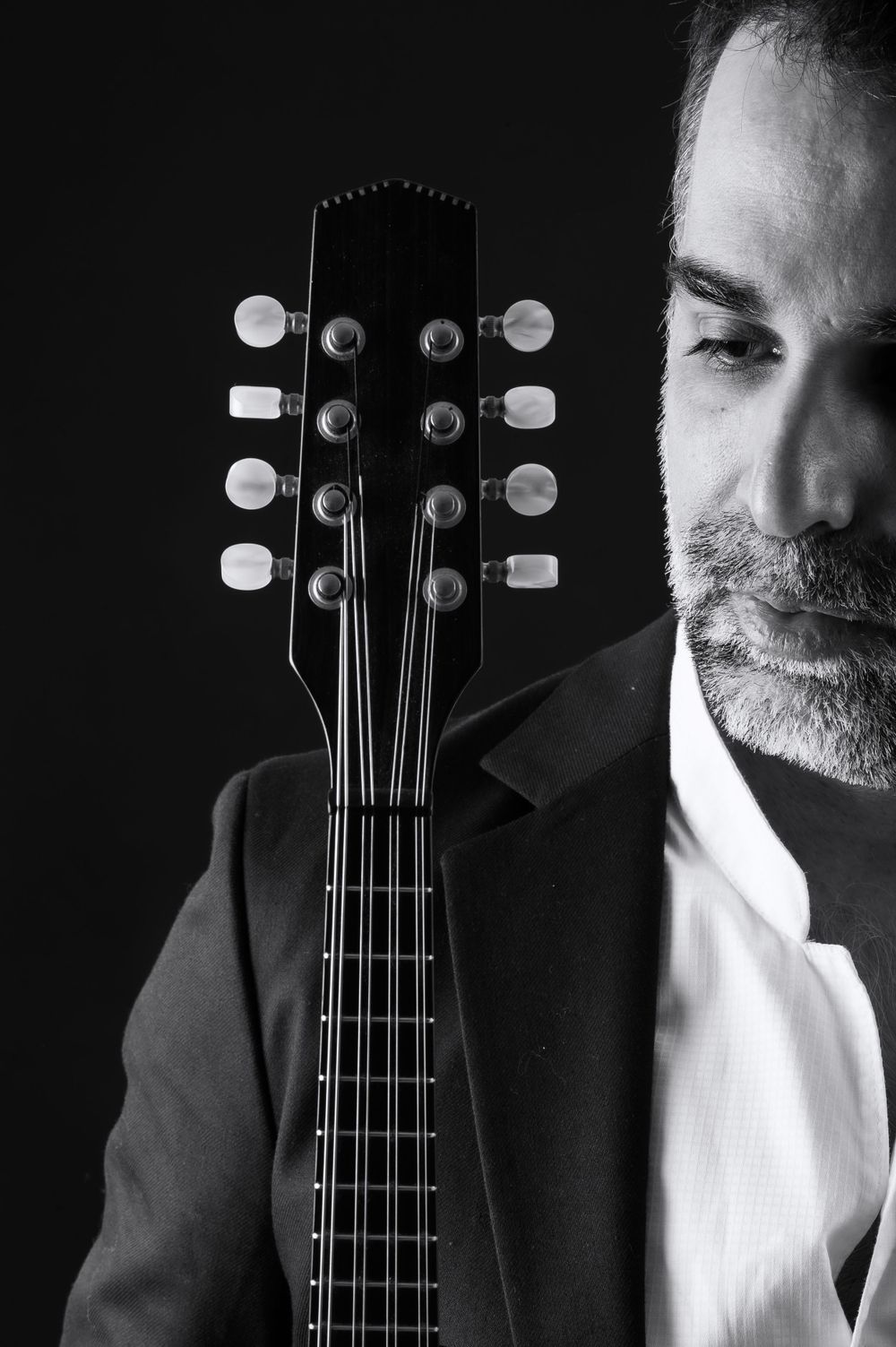 Close-up black and white photo of mandolin headstock and tuning pegs.