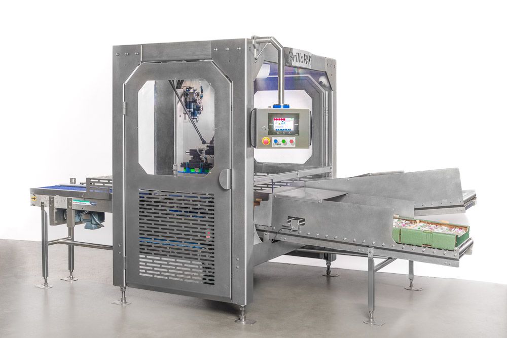 Stainless steel industrial packaging machine with conveyor belt and touchscreen control panel on white background.