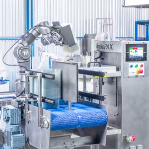 BrioPAK industrial robotic arm packaging machine with blue conveyor belt in a modern manufacturing facility.