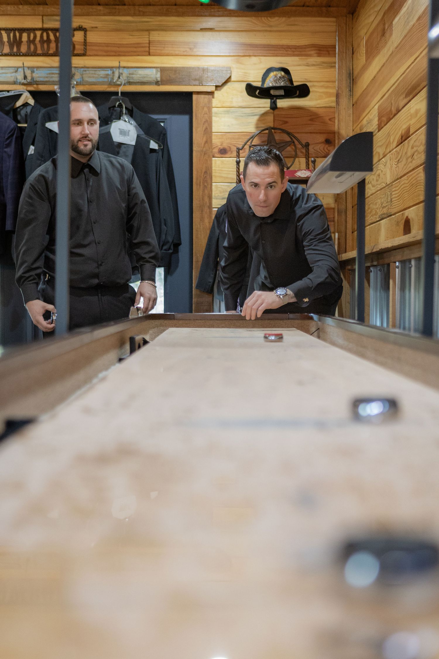 Groomsmen playing shuffleboard in the groom suite cabin at a Rockin' H Ranch wedding in Palm City, FL