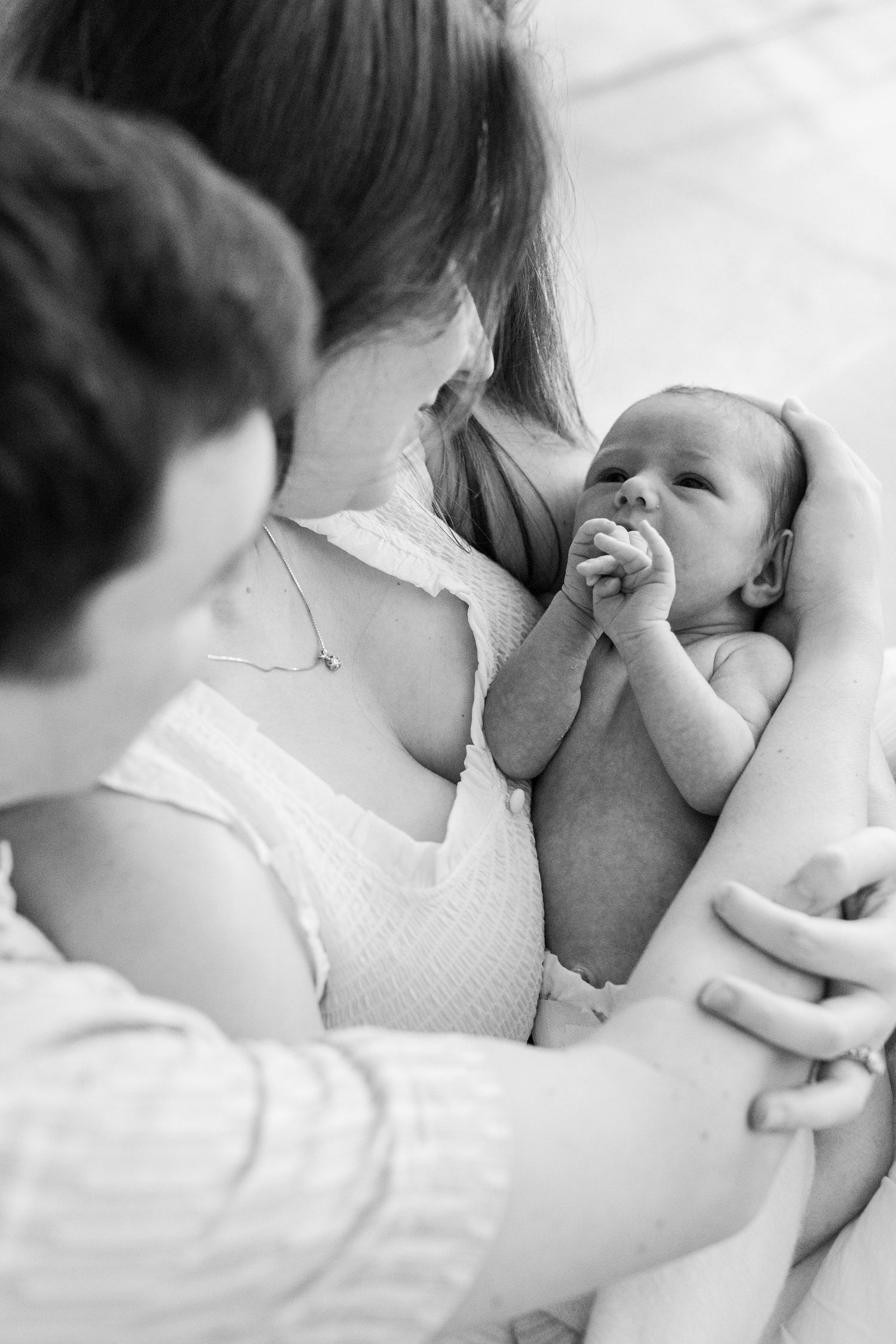 Black-and-white portrait of a mother, father, and newborn. In-home lifestyle newborn session in Guaynabo, Puerto Rico.