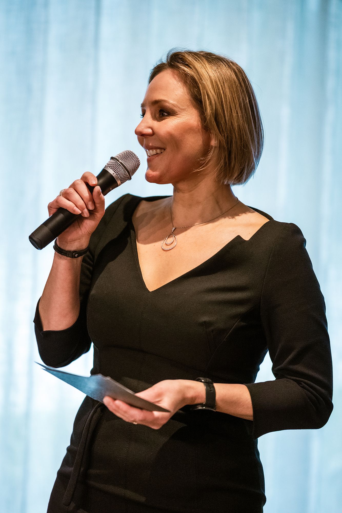 Amy Gille als spreker met microfoon tijdens een bedrijfsevent, gefotografeerd door Bart Boodts Photography