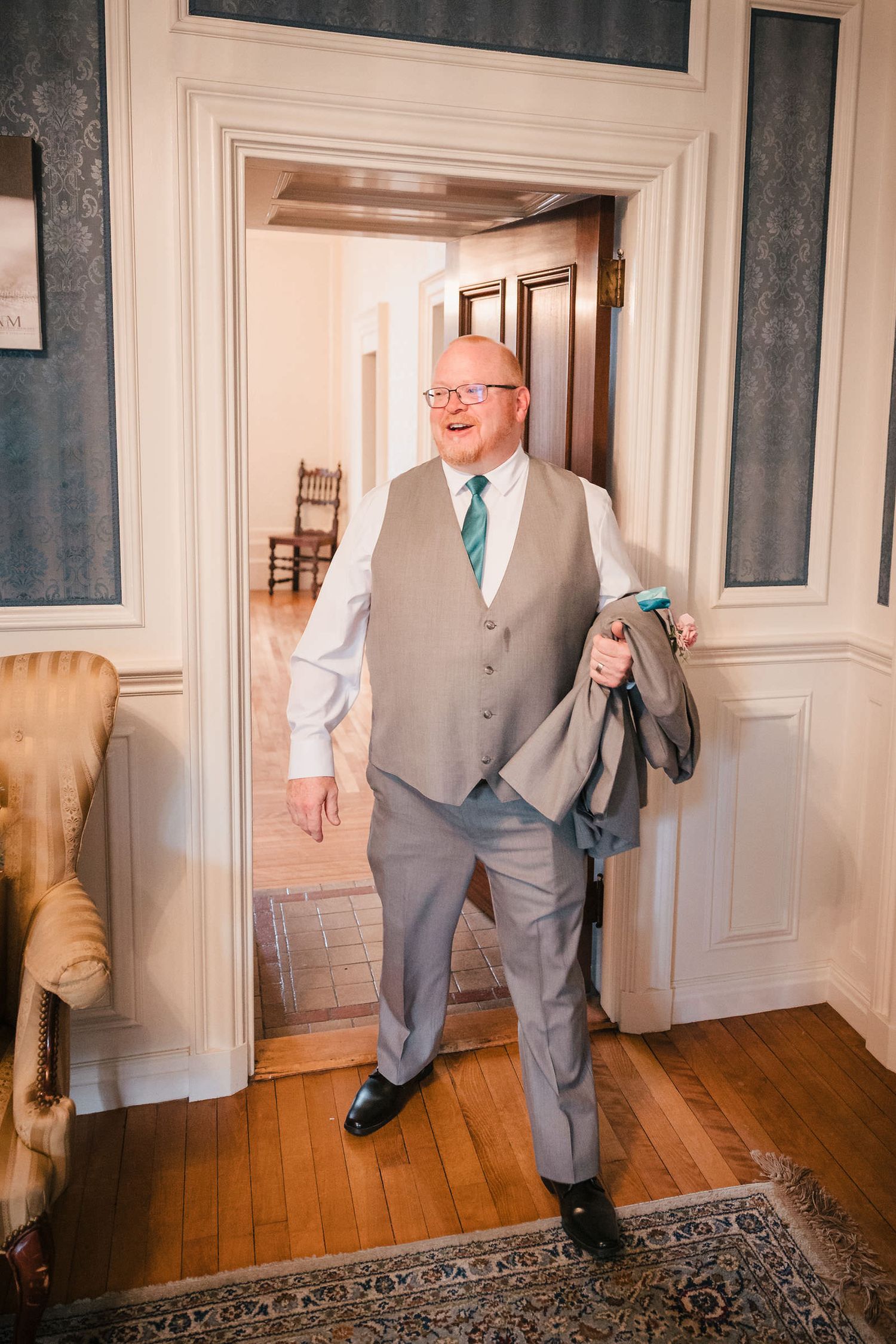 Bride's father walking into the room, dressed and ready, moments before their first look.