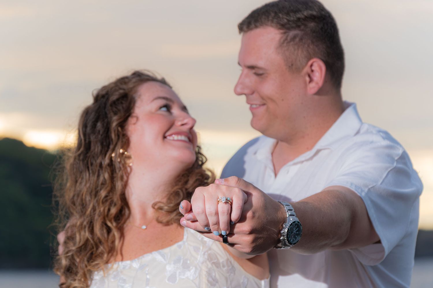 Couple standing together outdoors near tropical plants and patio furniture at a luxury resort.