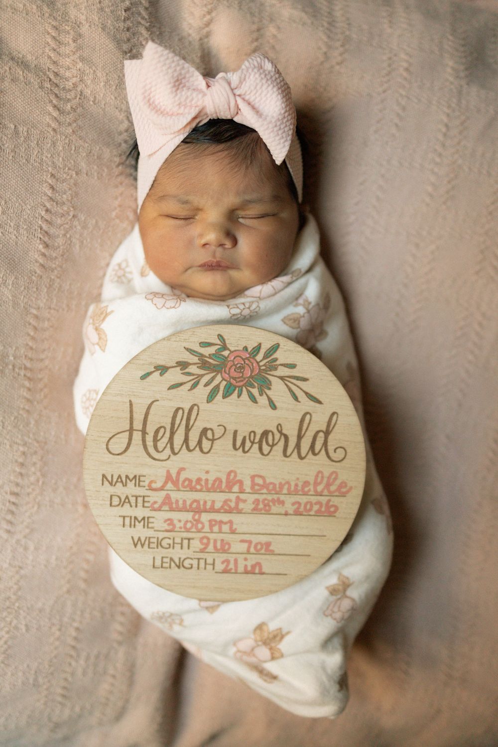 Newborn baby girl Nasiah Danielle, born August 18 2026, 9lb 7oz, 21in, swaddled with Hello World sign.