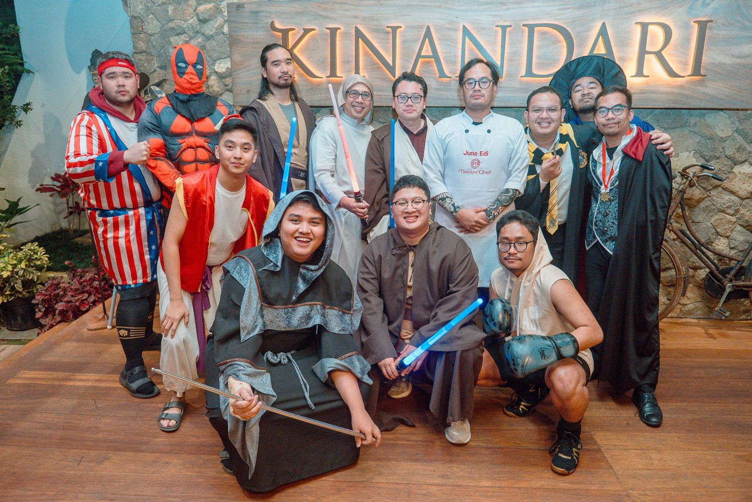 Group of costumed people posing together at Kinandari venue, featuring Marvel and fantasy characters at a costume event.