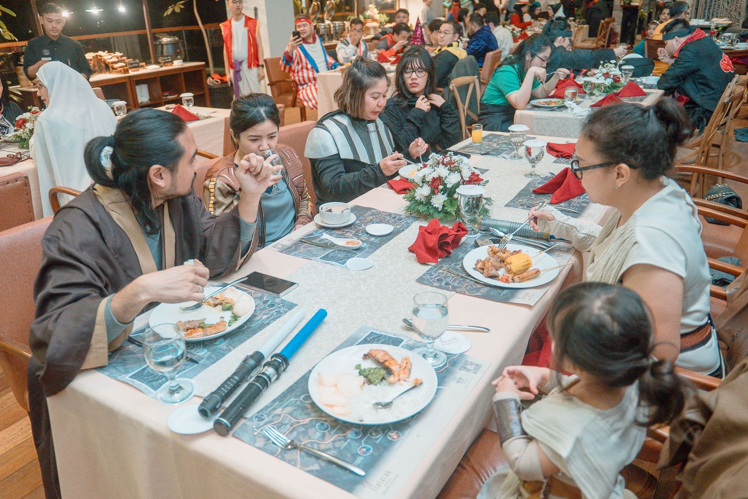 Group of people dining together at a festively decorated restaurant table during a holiday celebration event.