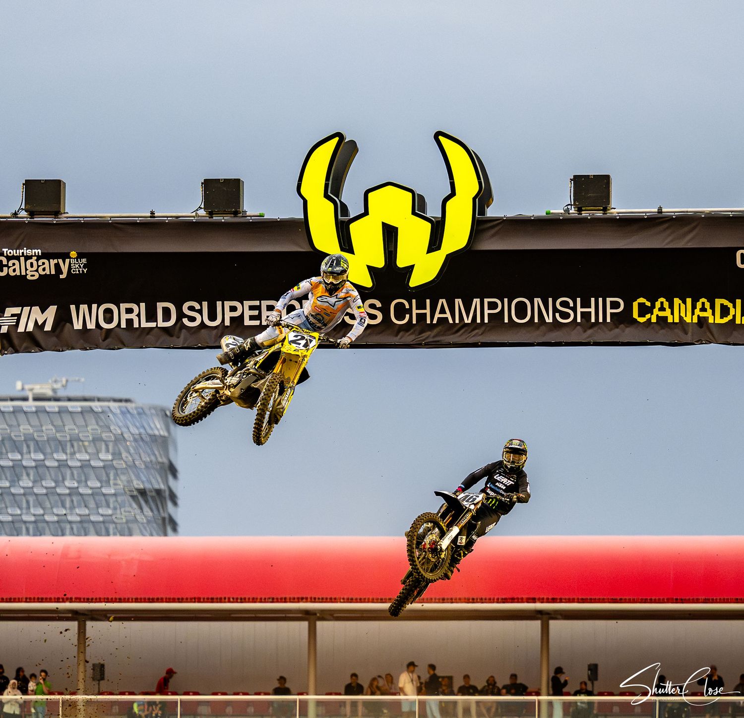 Two motocross riders soar through the air at the FIM World Supercross Championship Canada event in Calgary.