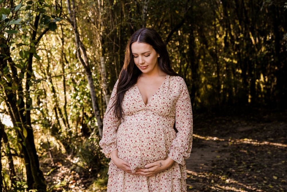 pregnant lady standing amongst trees
