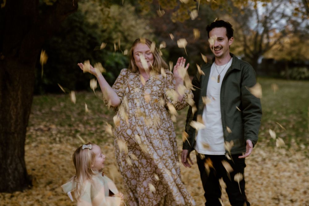Pregnant lady throwing autumn leaves