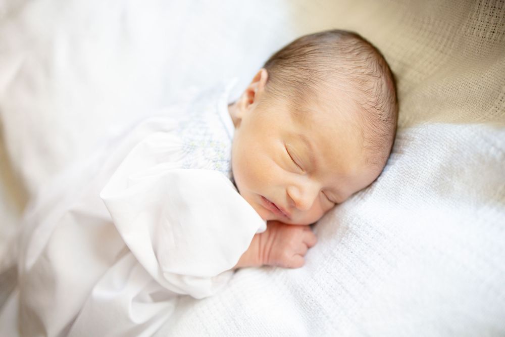 Peaceful newborn baby sleeping wrapped in white swaddle blanket, close-up portrait of serene infant University of Tennessee Medical Center.