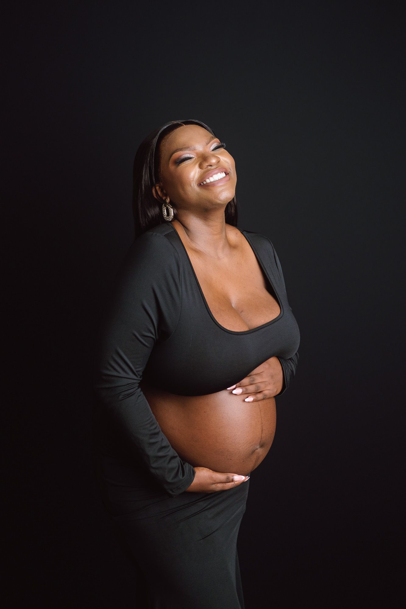 Pregnant mother laughing during a relaxed studio maternity portrait session