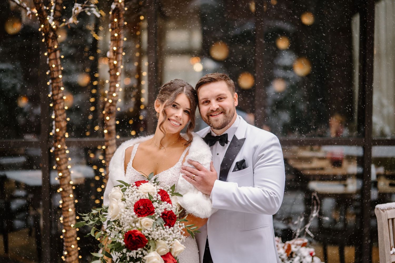 Bride and groom sitting closely on stone steps outside elegant venue, sharing an intimate moment in wedding attire.