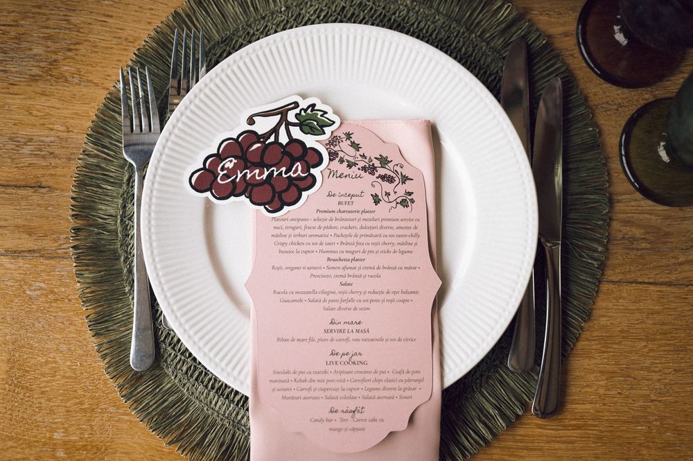 Elegant wedding place setting with personalized Emma menu card on pink napkin, white plate, and woven charger.