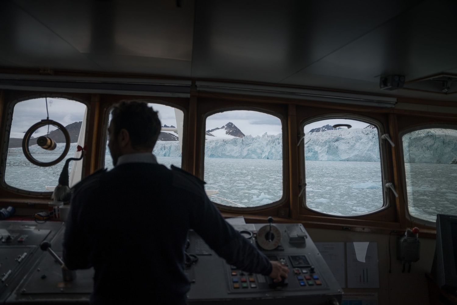 Commandant du Polarfront à la barre, front glaciaire visible par les fenêtres de la passerelle
