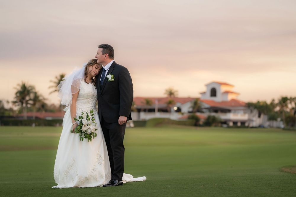 Bride and groom embracing on the golf course at sunset at The Wanderers Club in Wellington, FL