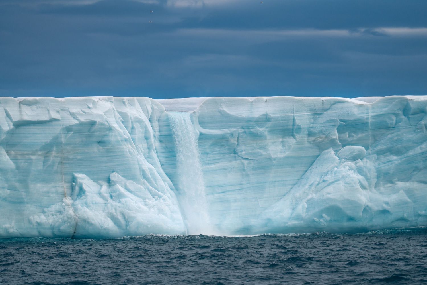 Front de glace continu et régulier de Bråsvellbreen, cascade dans l'axe du cadre