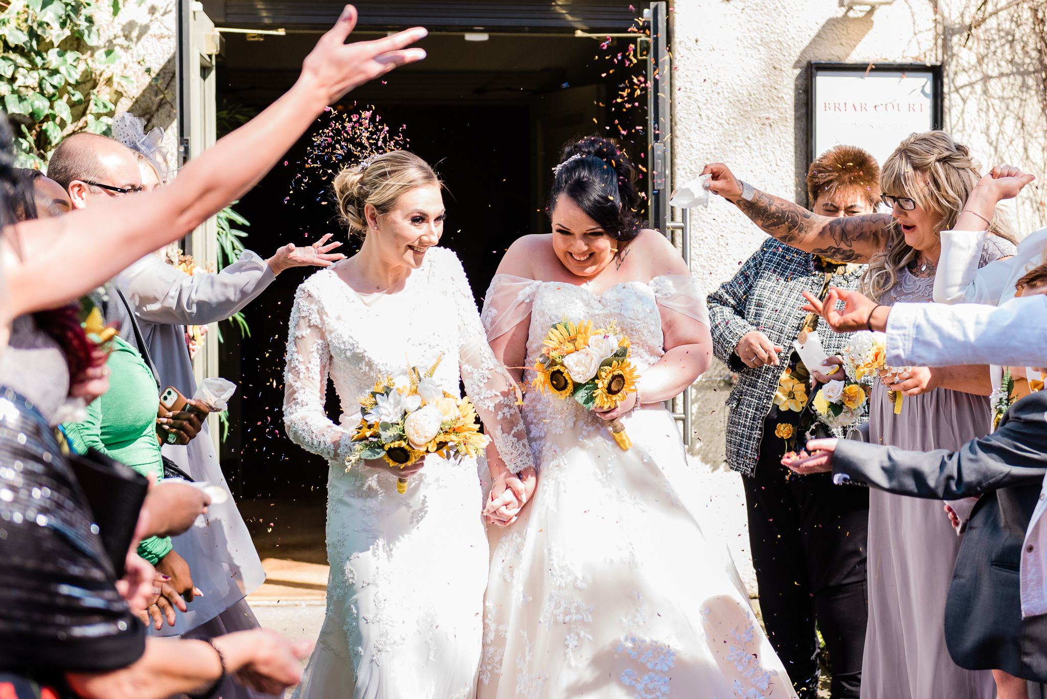 Guests throw confetti on the brides during this lesbian wedding