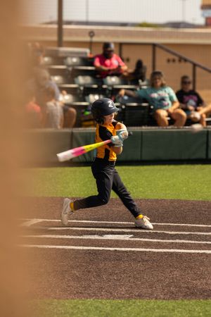 Youth baseball player swinging at the plate during a competitive baseball game in Oklahoma.