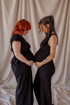 Two women posing together in coordinated black outfits during a creative studio portrait session.