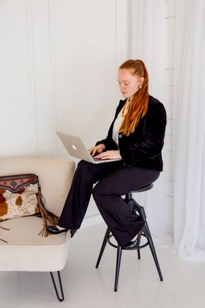 Professional lifestyle portrait of a woman working on a laptop during a business branding session.
