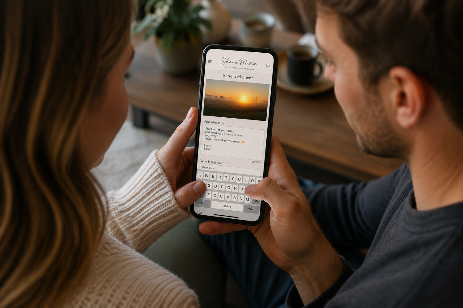 Couple viewing a recipe card app on a smartphone with a sunset photo and keyboard visible.