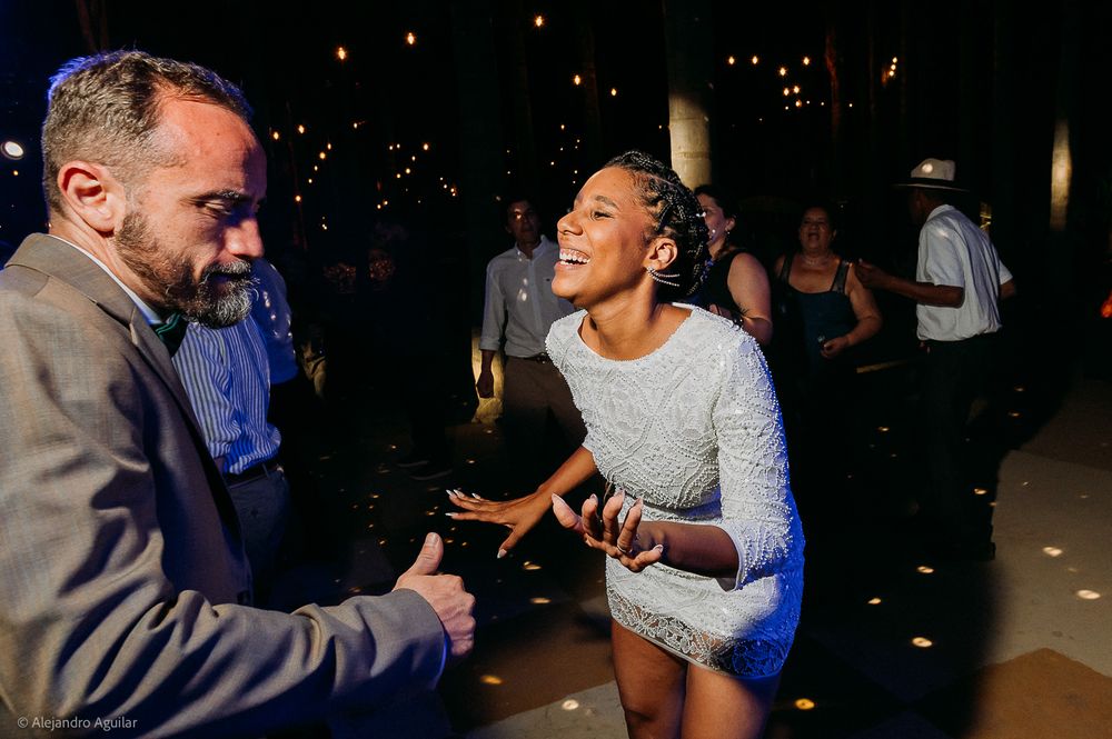 Two people dancing and laughing joyfully at an elegant evening reception party.