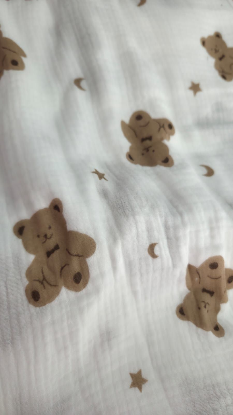 White muslin fabric featuring brown teddy bears, gold stars, and crescent moons in a cute baby pattern.