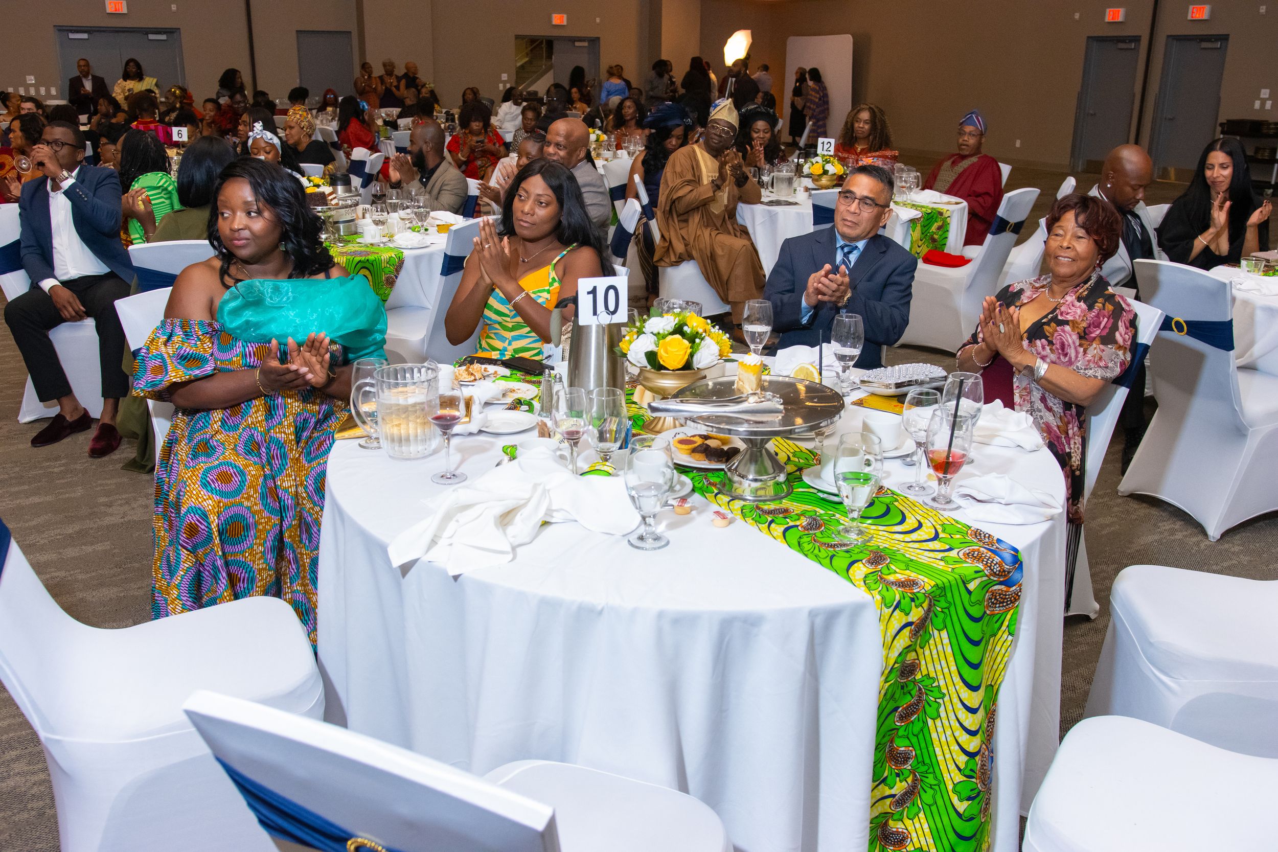 Guests seated at decorated tables during a formal banquet event in a large hall.