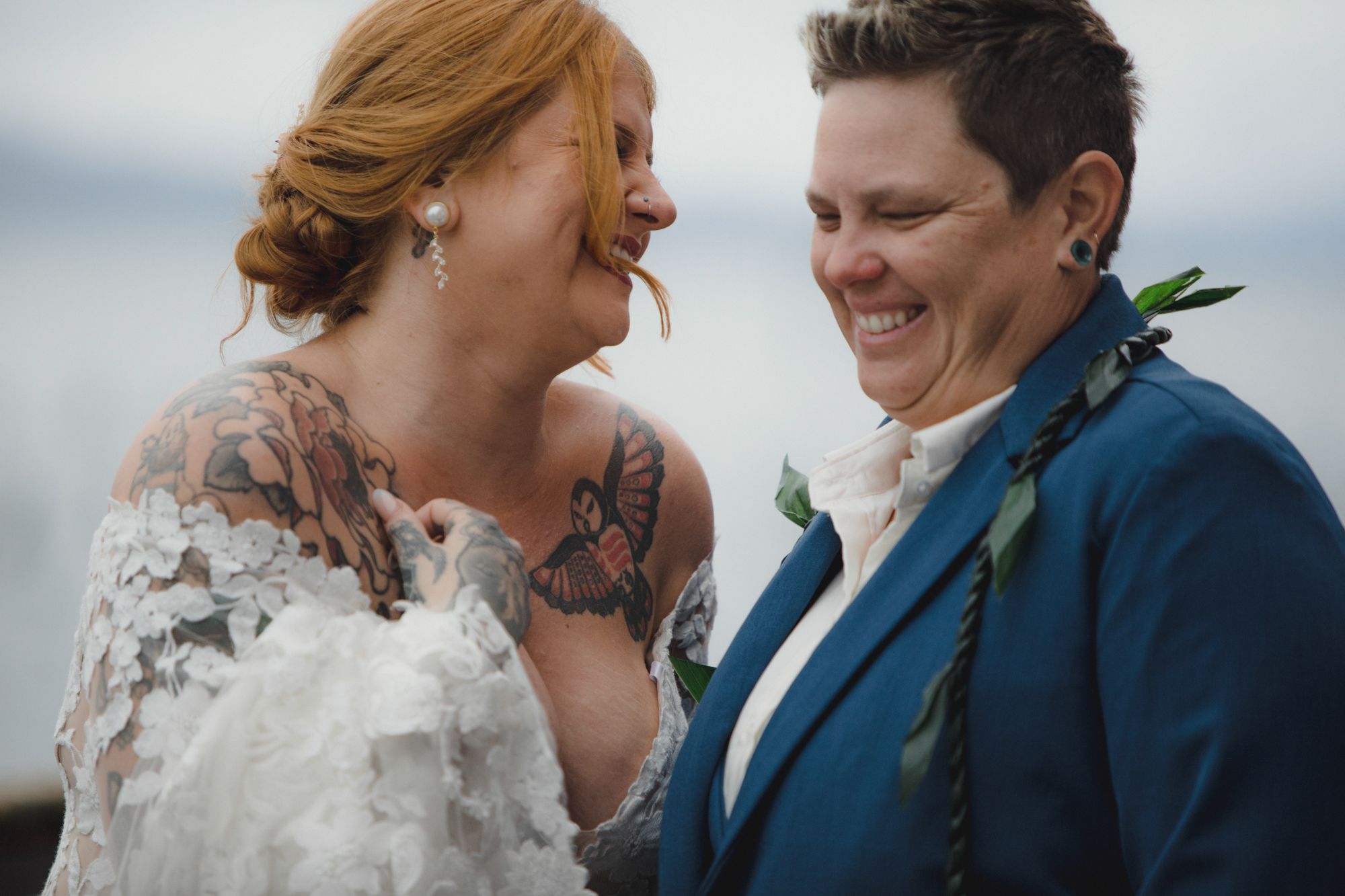 Joyful couple sharing intimate moment during coastal wedding celebration.