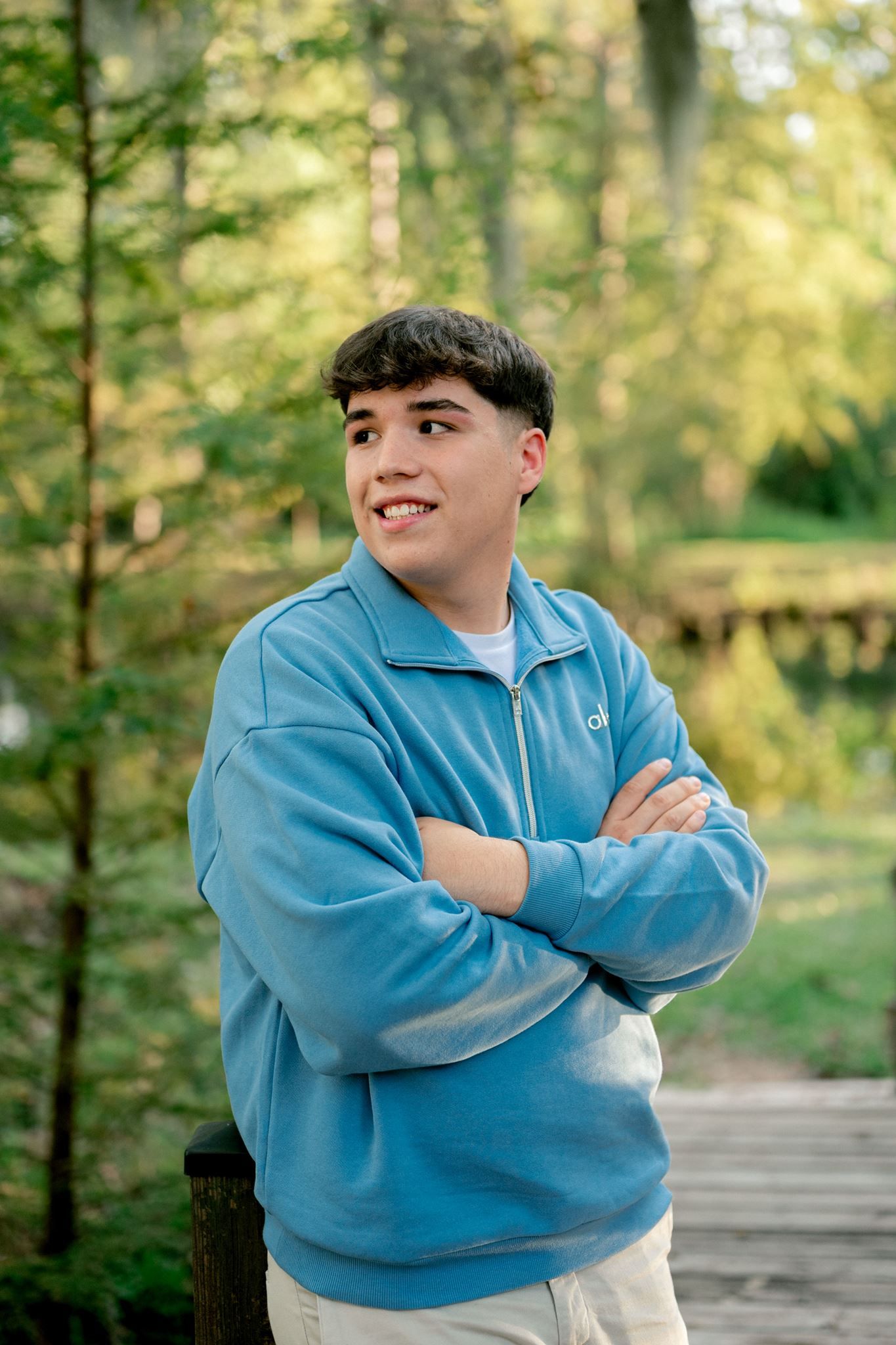 Senior boy smiling on bridge located in Cypress, Texas.