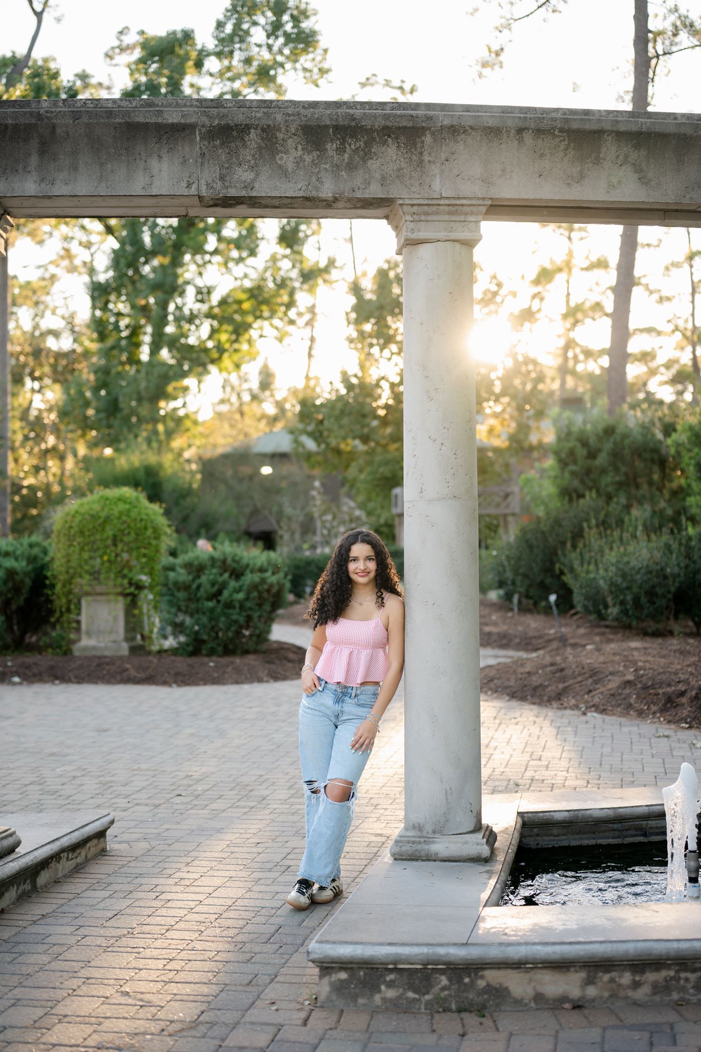 Natural senior portrait of Cristina wearing distressed jeans and Adidas sneakers in Humble, Texas.