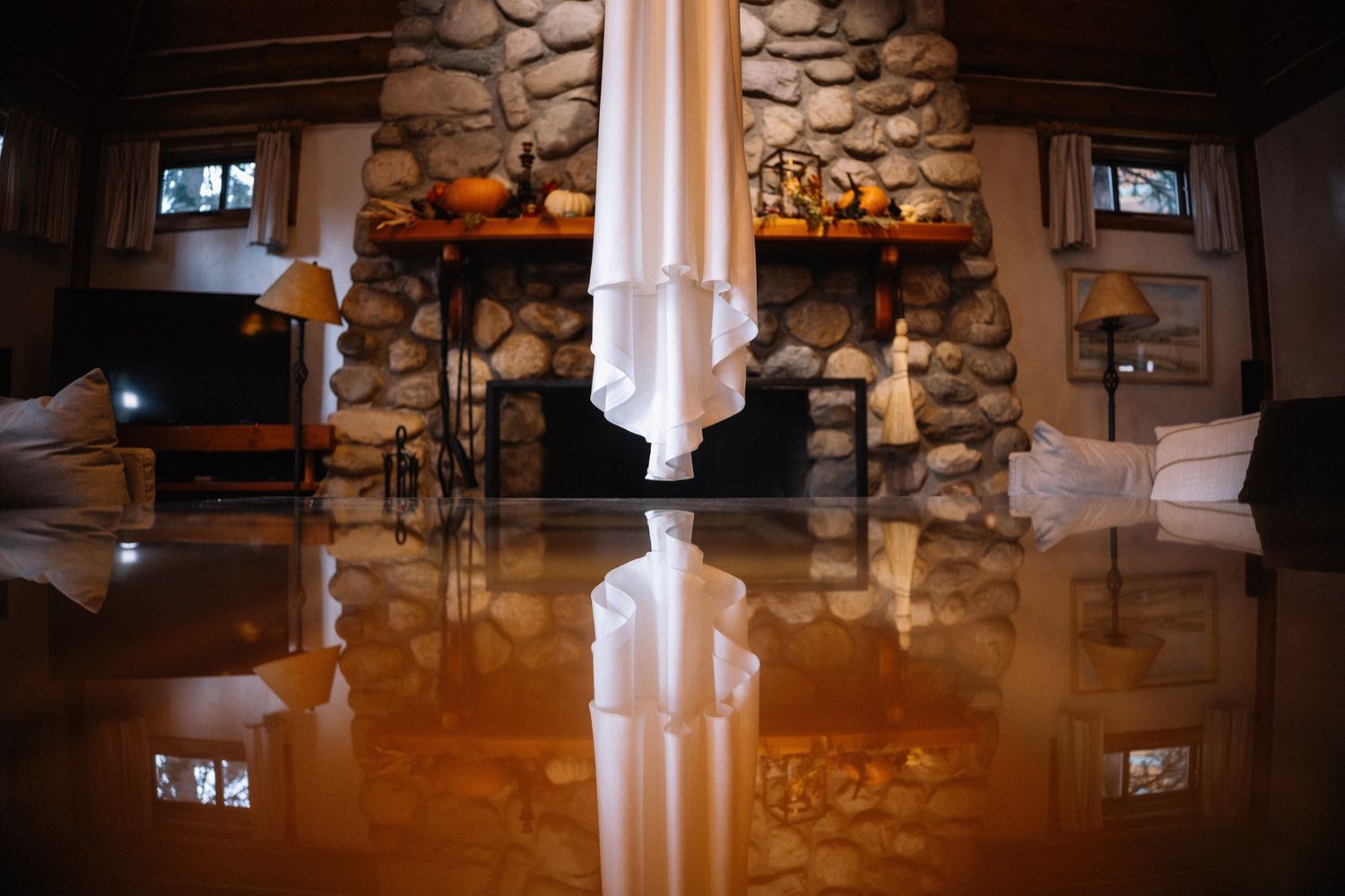 Wedding dress hanging by the stone fireplace at The Post Hotel, Lake Louise