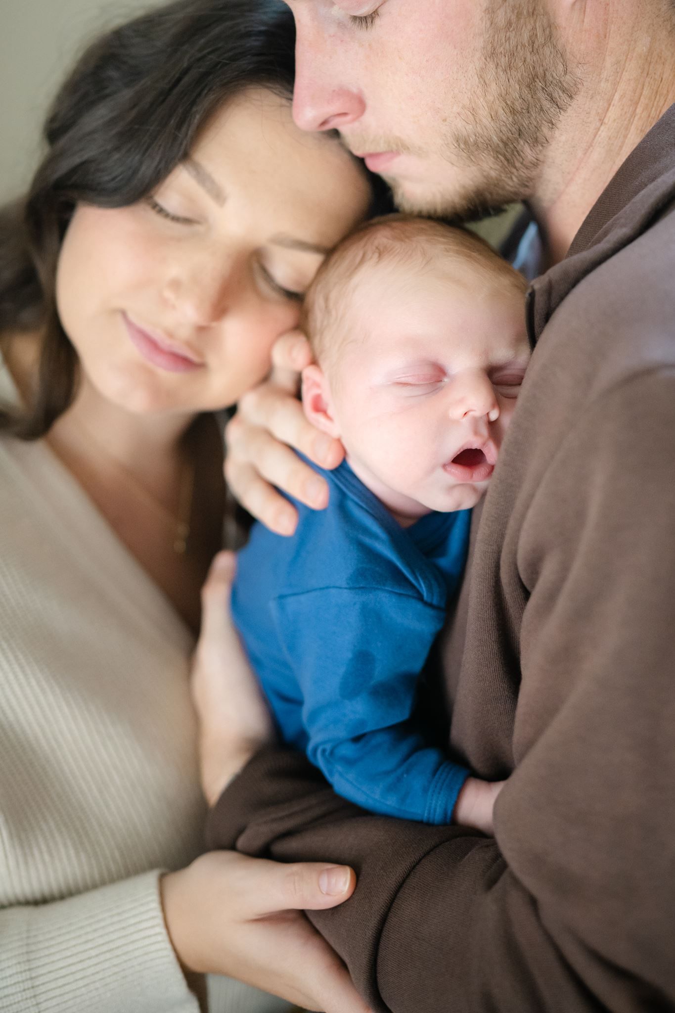 New parents cuddling their newborn.