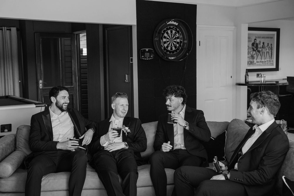 Groomsmen enjoying a whiskey during groom prep at Deer Park in Devon