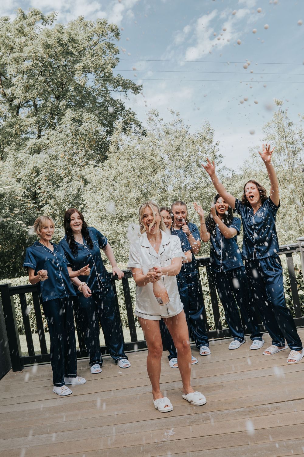 Bride and her bridesmaids popping champagne at Deer Park Summer Wedding - Devon
