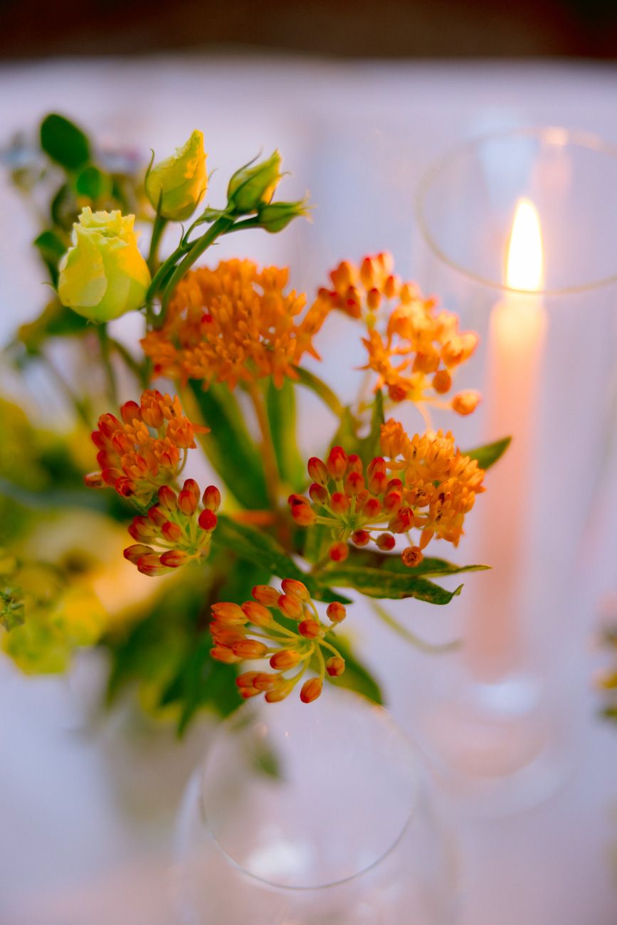 Vibrant colourful floral centerpiece decorating a rehearsal dinner table in a Lake Garda vineyard