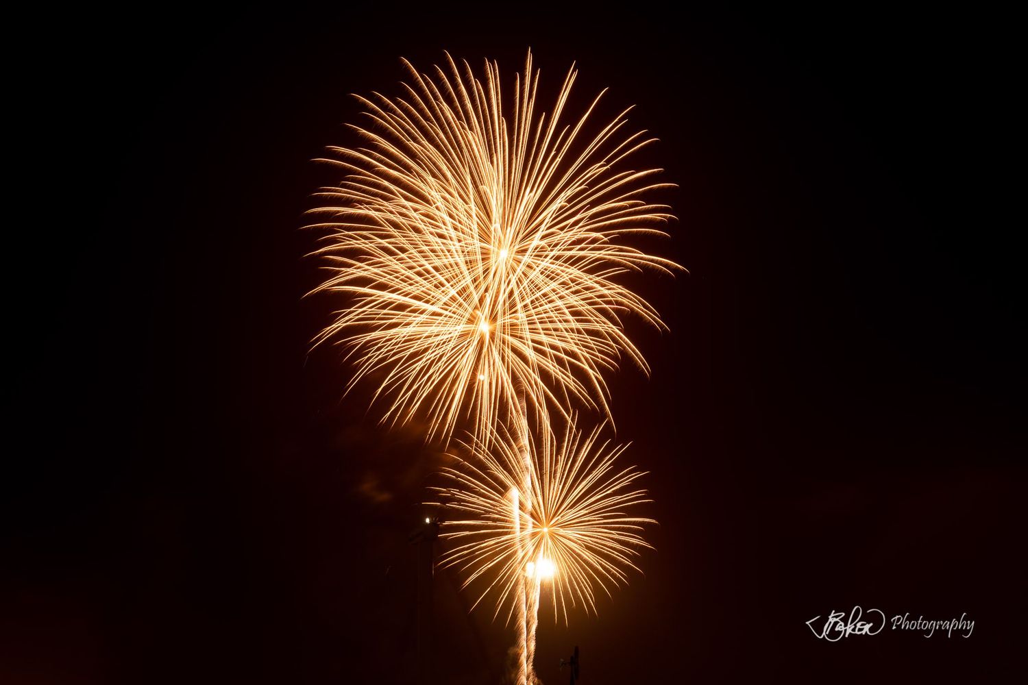 Golden fireworks bursting in the night sky, captured by KBee Photography.