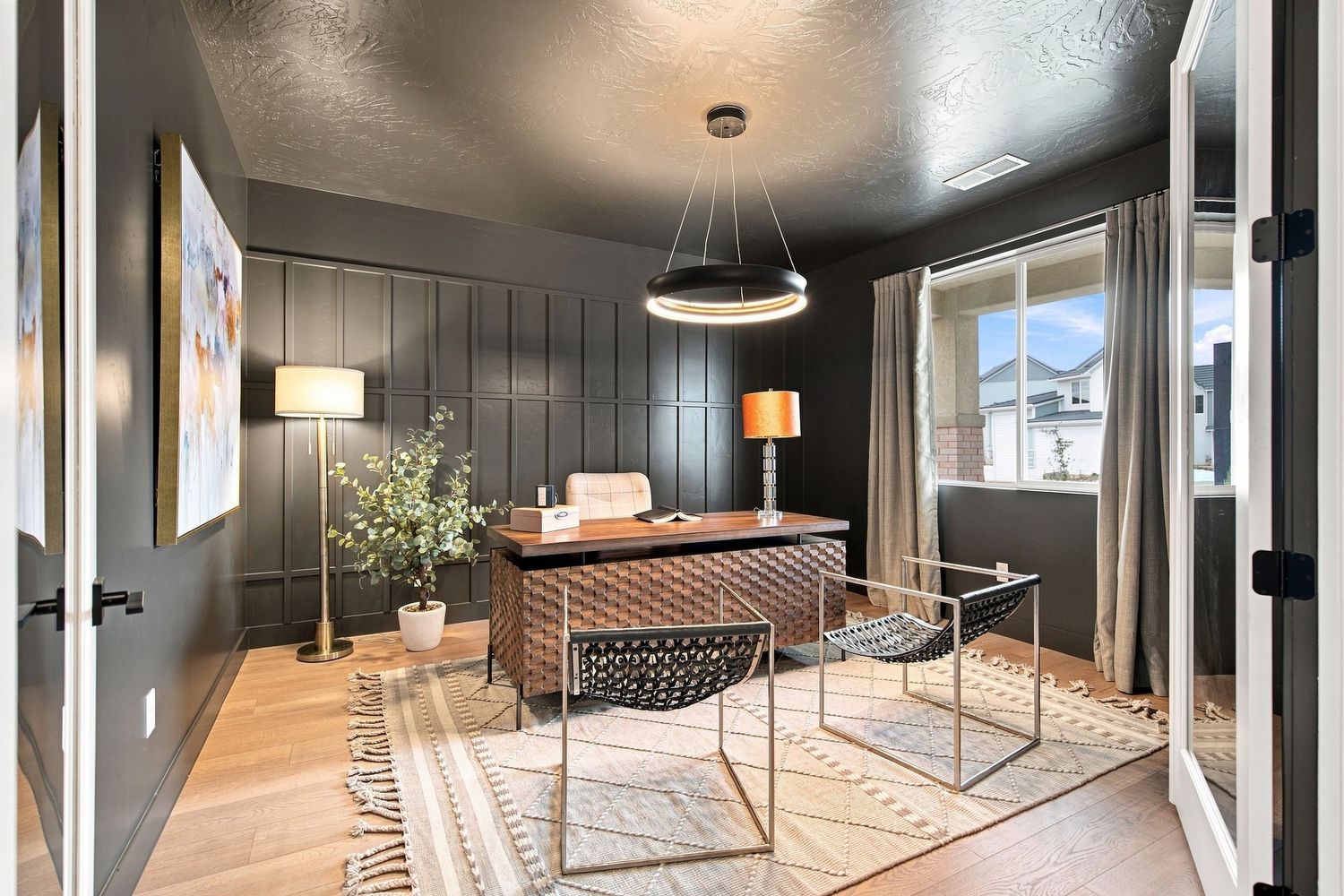 A woman walks through a modern Southern Utah home with shiplap walls, large windows, and light wood floors