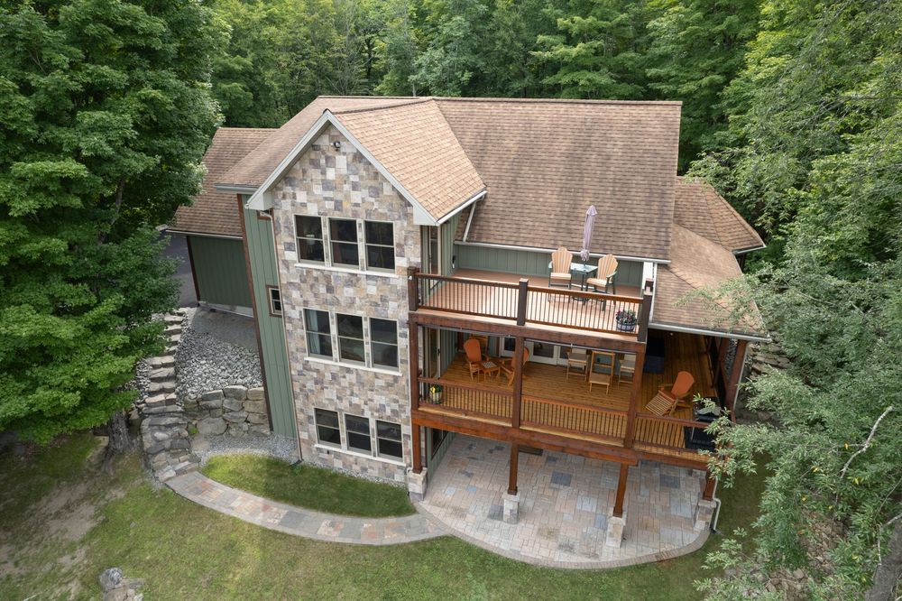 Aerial view of a stunning stone and wood home in Schroon Lake, NY.