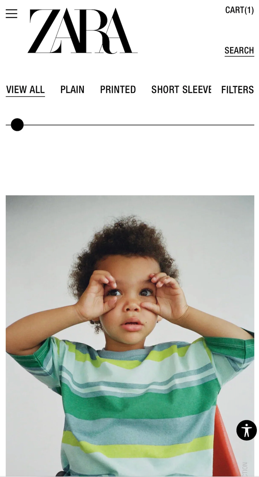 Toddler in green striped Zara t-shirt holds hands over eyes playfully on Zara product page.