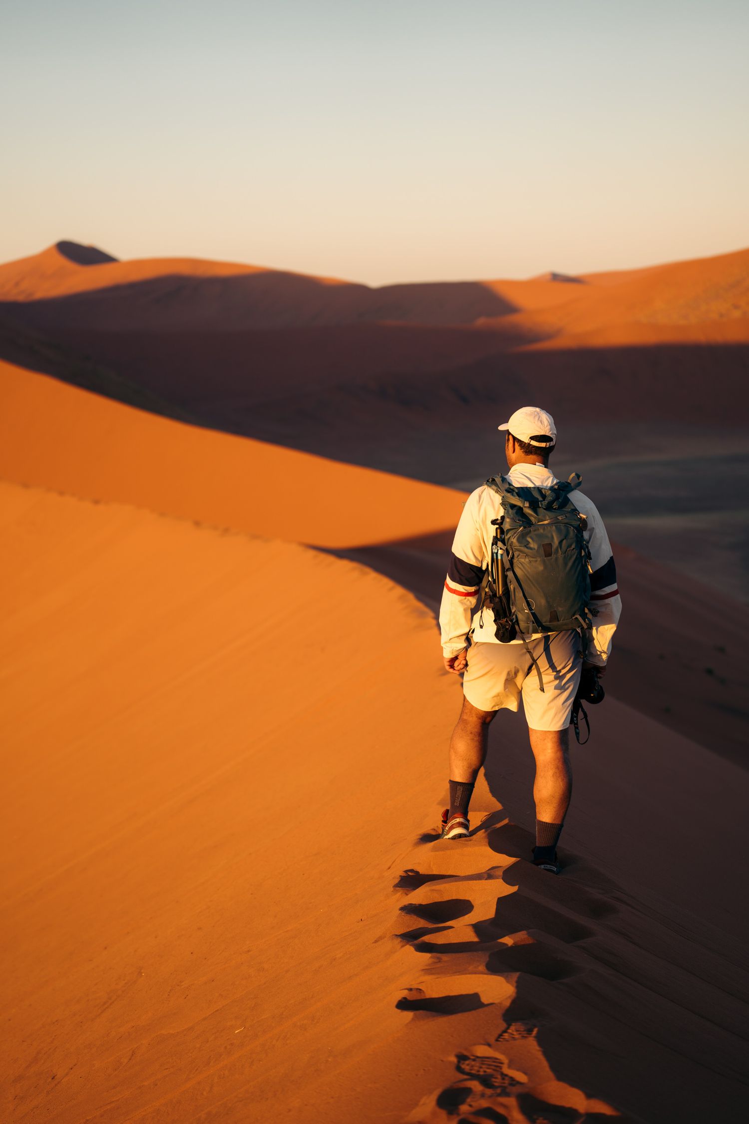 homme qui marche de dos dans le sable de la dune 45 à sossusvlei au lever du soleil
