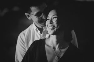 Black and white portrait of smiling couple in soft lighting.