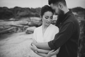 Black and white photo of couple holding each other closely.
