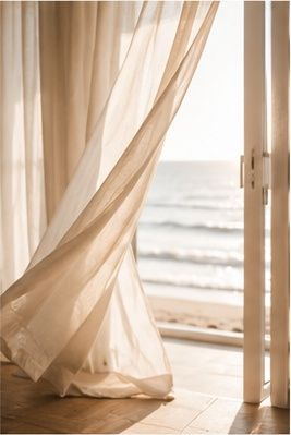 Sheer curtains gently filtering natural sunlight through a bright window in a serene, minimalist interior setting.