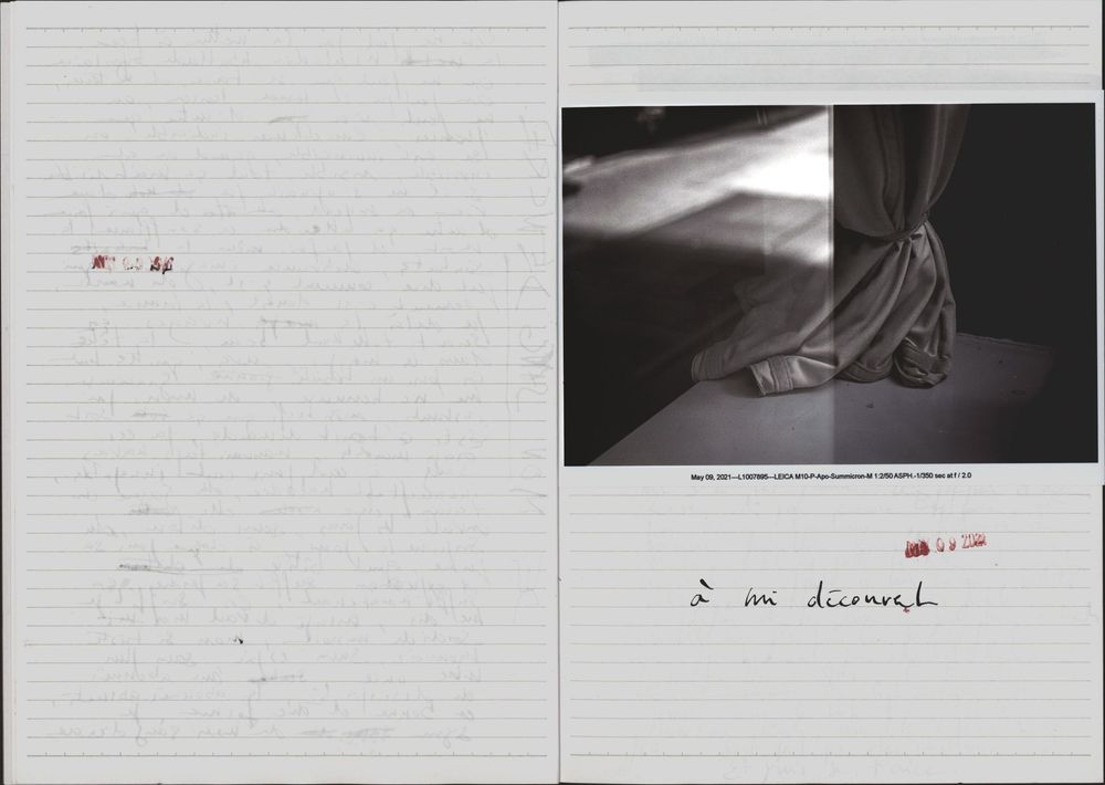 Open book showing handwritten text on left page and black-and-white photo of draped fabric on right page.