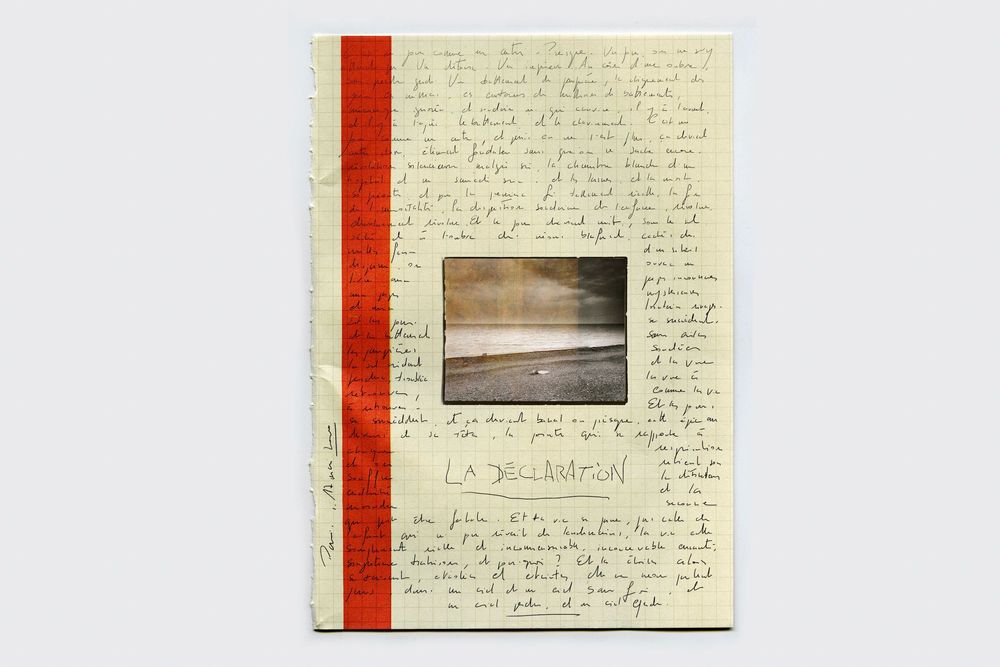 Handwritten journal page with red spine binding and embedded landscape photo, featuring cursive script text throughout.