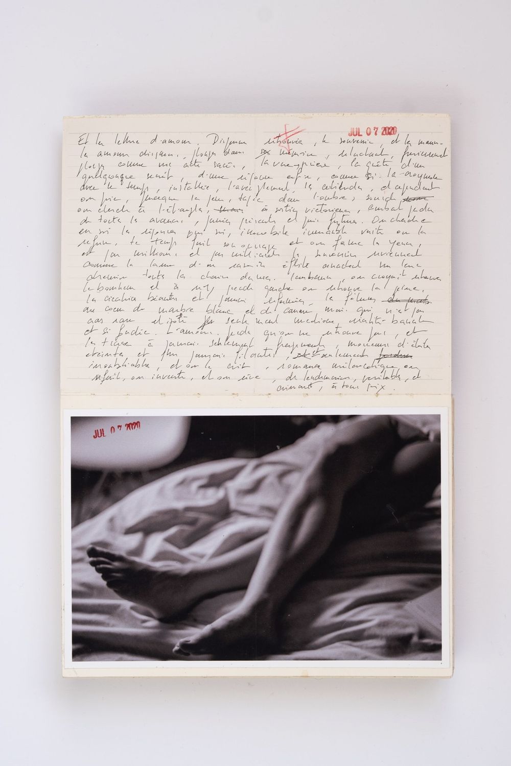 Handwritten French letter on paper above a black and white photograph of a reclining figure on rumpled bedding.