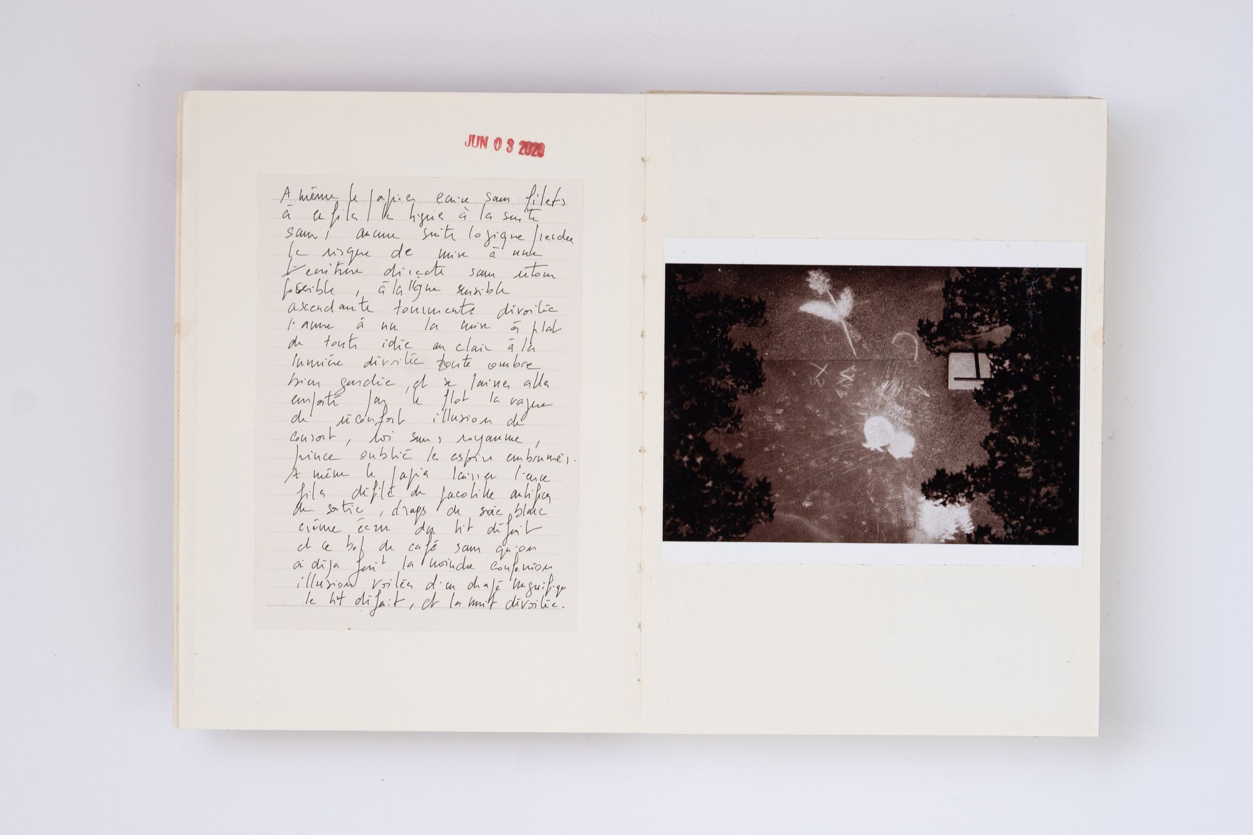 Open book with handwritten journal notes on left page and a dark photograph on the right page.